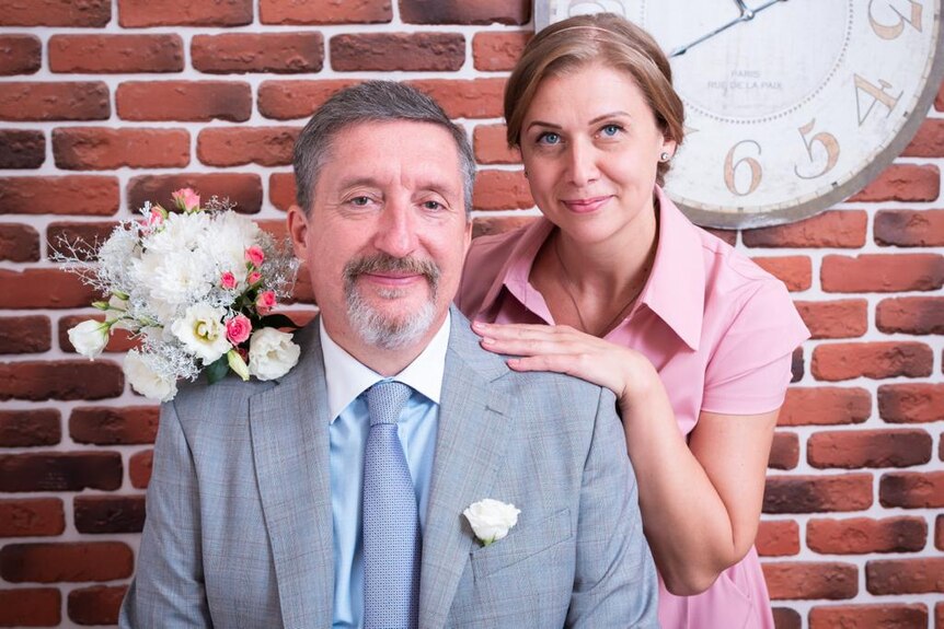 A woman in a pink dress and manin grey suit in a wedding photo