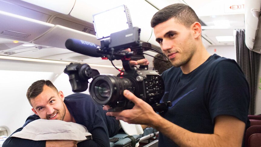 Tom Rogic fools around with a video camera on the Socceroos charter flight