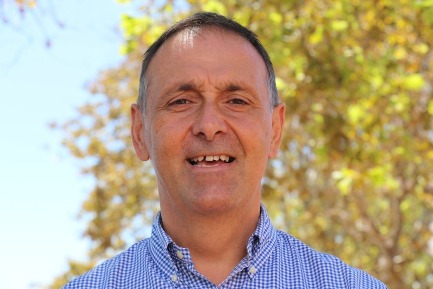 Liberal candidate for Hillarys and incumbent Peter Katsambanis smiles at the camera in an outdoor setting.