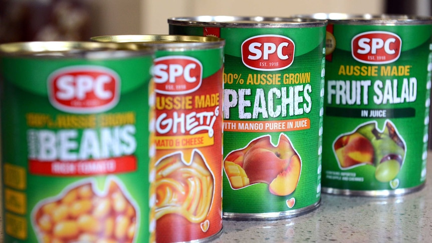 Can of SPC fruit salad, peaches and beans on a kitchen counter.