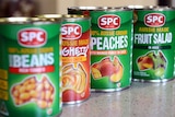 Can of SPC fruit salad, peaches and beans on a kitchen counter.