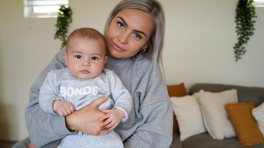 Mid-shot of Jayme Lees with her baby on her lap 