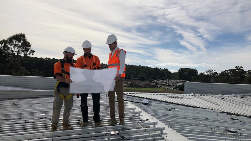 Workers on the roof of the Port Macquarie Base Hospital