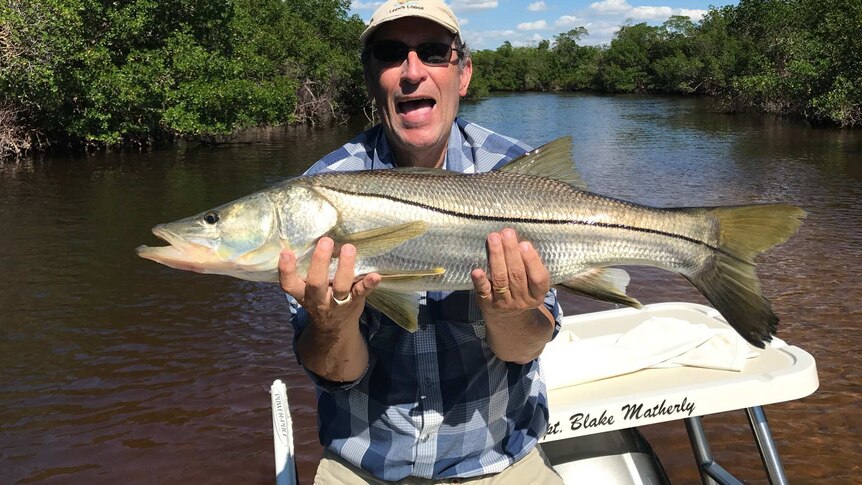 David Blanchflower holds a massive snook fish while out fishing.