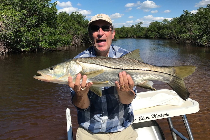 David Blanchflower holds a massive snook fish while out fishing.