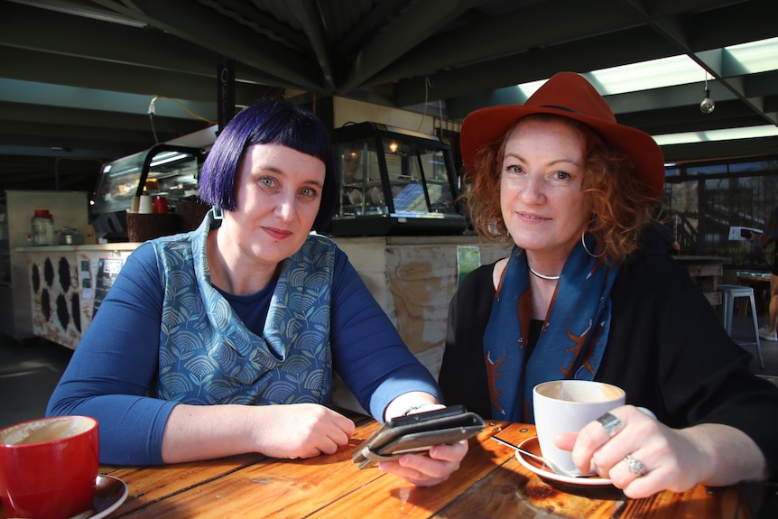 Melanie Bainbridge and Harry Deluxe sitting in a cafe.