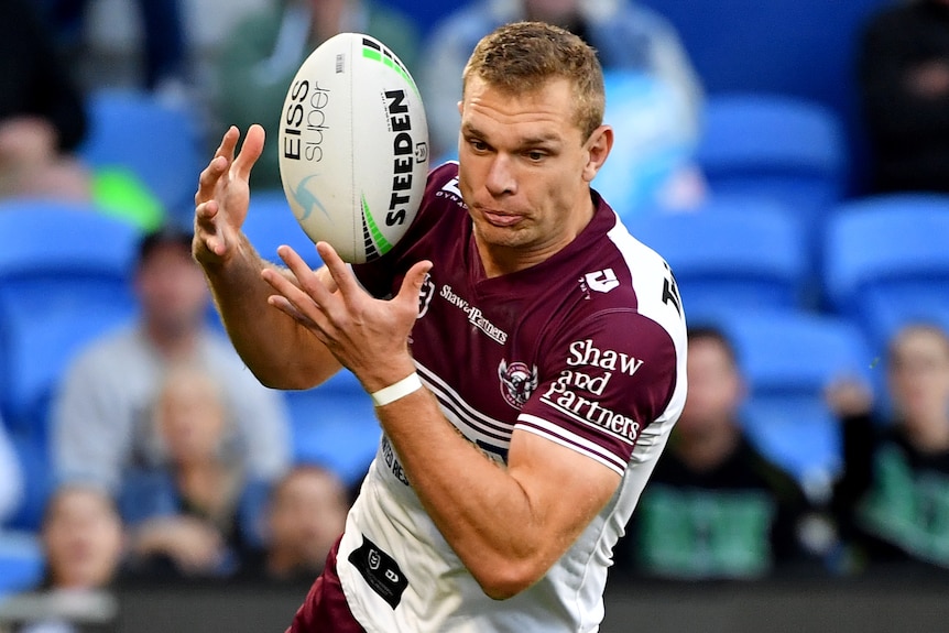 Manly Sea Eagles player Tom Trbojevic catches the ball with both hands.