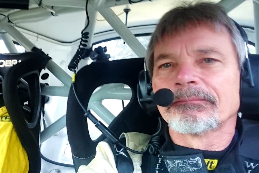 Dennis inside a race car.