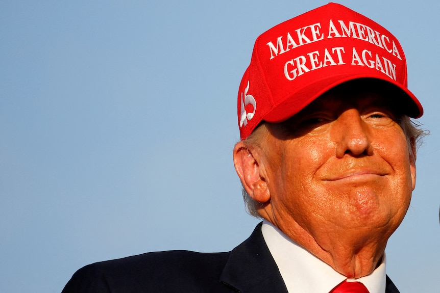 Donald Trump au bonnet rouge sourit 