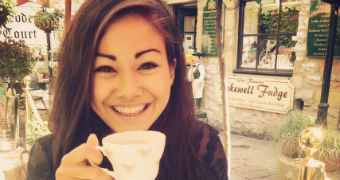 A woman with a big smile on her face holding a cup of tea