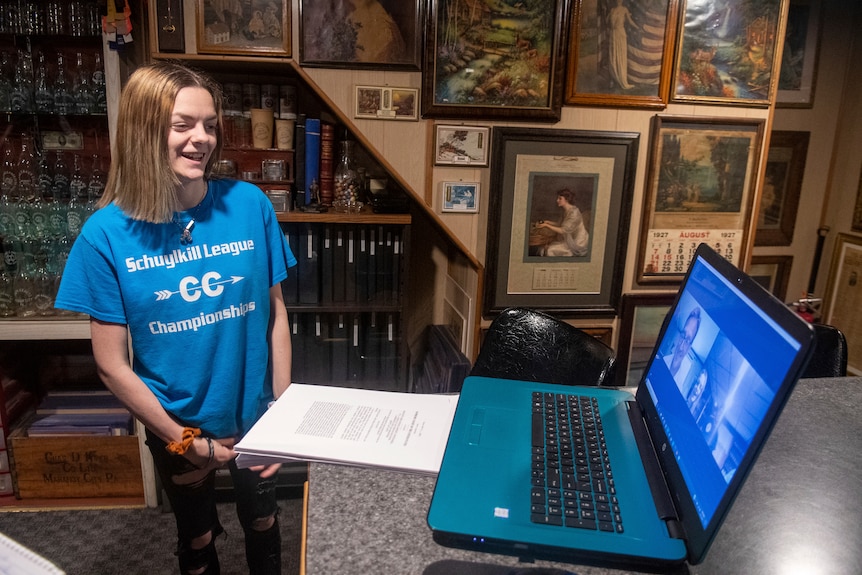 Brandi Levy smiles as she speaks to a man via a laptop screen.