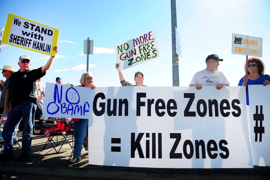 Protesters line the street in front of the Roseburg Regional Airport