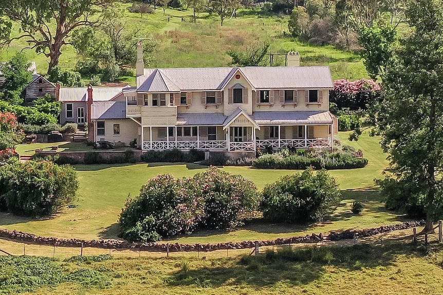 A large two story house surrounded by green landscaped garden. 