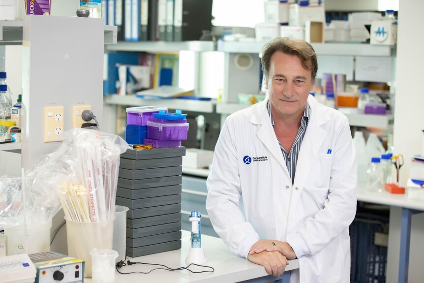 A man in a white coat in a lab