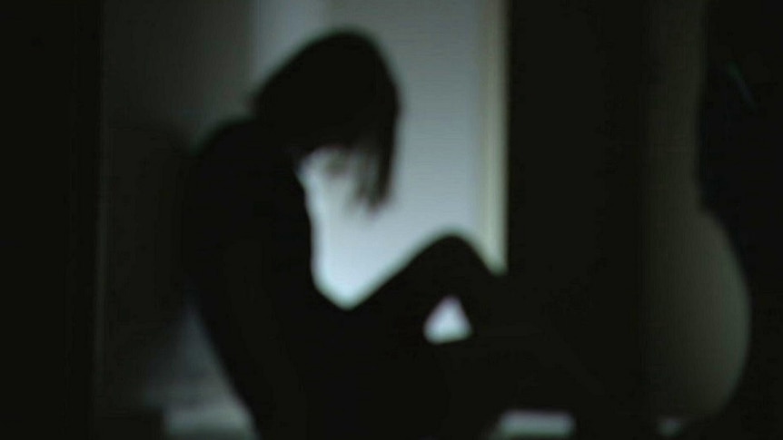 A blurry image of a woman sitting on the floor in shadow. Ausnew Home Care, NDIS registered provider, My Aged Care