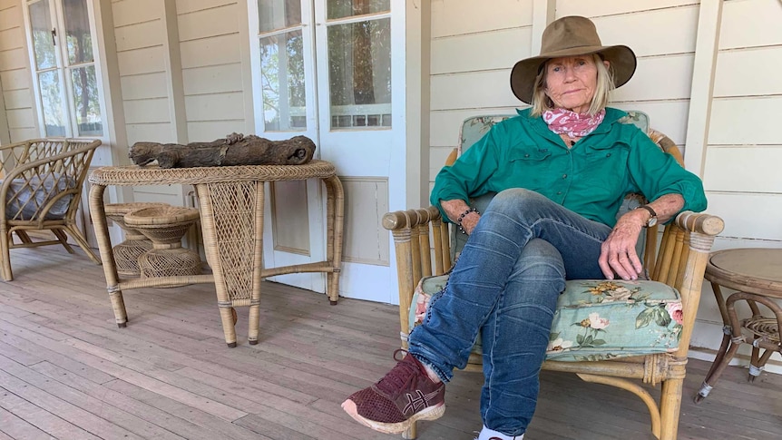 Rosemary Champion Longreach Grazier sitting on her porch in an akubra and green shirt