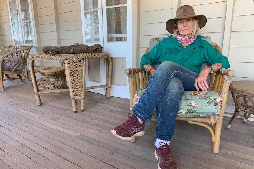 Rosemary Champion Longreach Grazier sitting on her porch in an akubra and green shirt