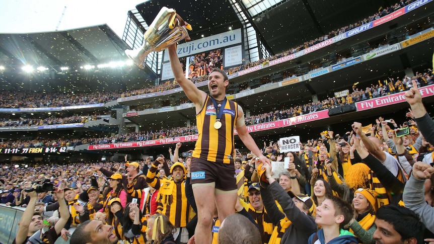 On a high ... Brent Guerra lifts the AFL premiership cup after Hawthorn won the grand final