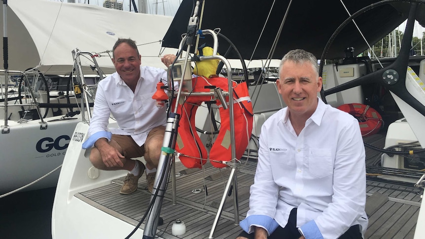 Brothers Derek and Martin Sheppard sitting on the stern of their yacht Black Sheep.
