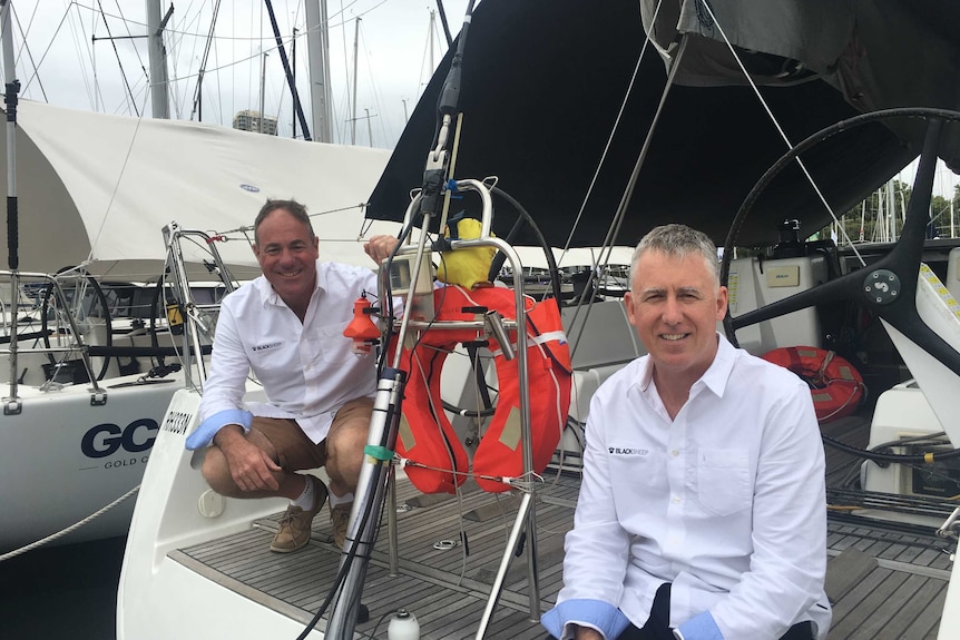 Brothers Derek and Martin Sheppard sitting on the stern of their yacht Black Sheep.