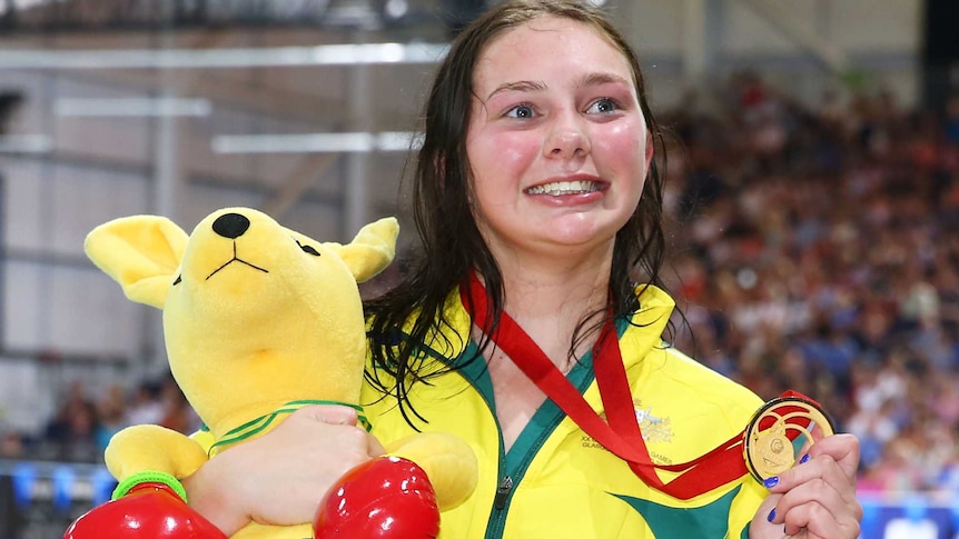 Australia's Maddison Elliott shows her gold medal after winning the parasport S8 100m freestyle.
