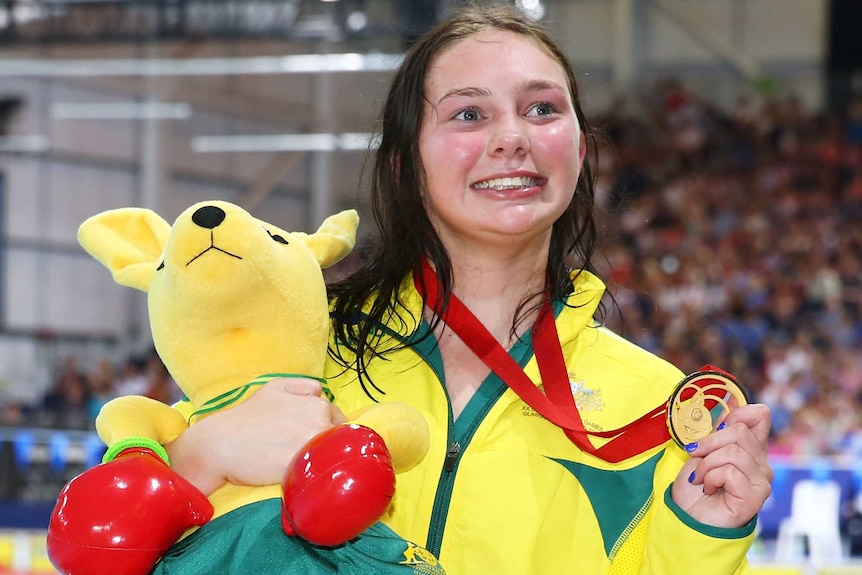 Australia's Maddison Elliott shows her gold medal after winning the parasport S8 100m freestyle.