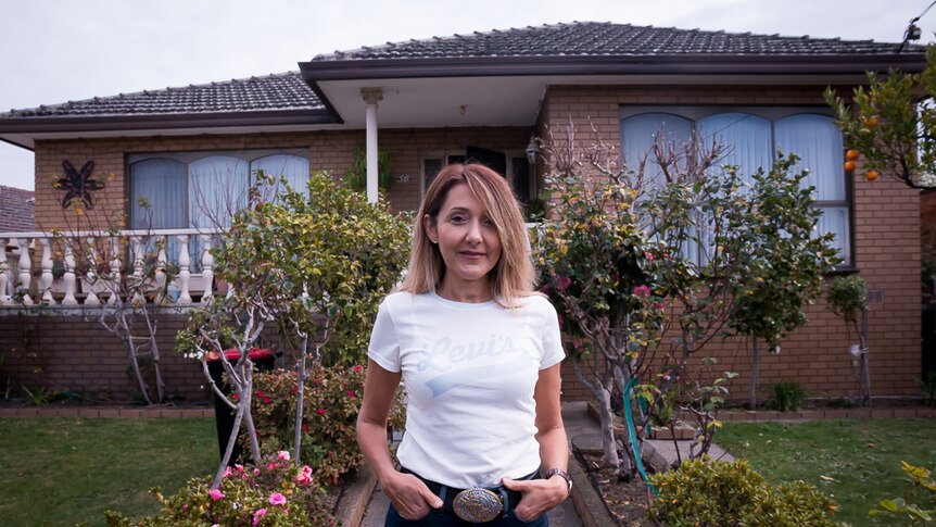 Lina Barber stands outside the house in which she was exposed to asbestos as a child.