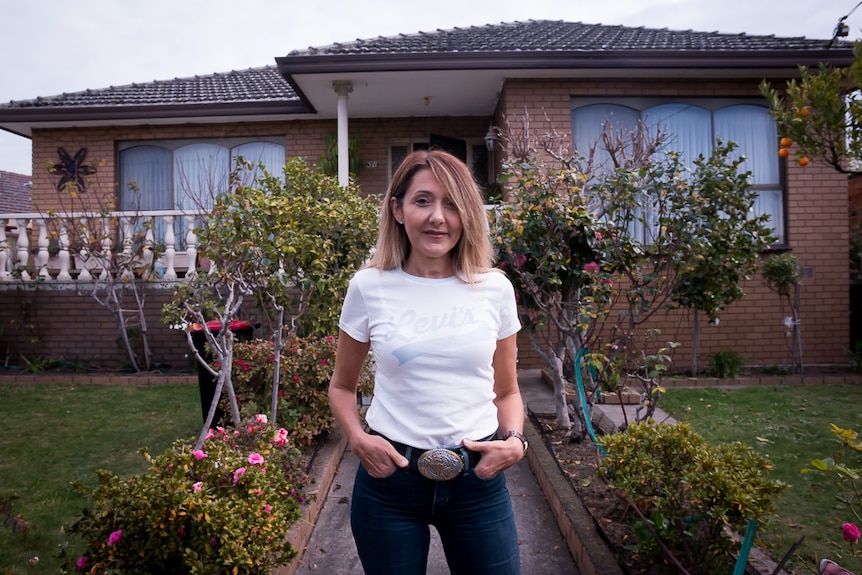 Lina Barber stands outside the house in which she was exposed to asbestos as a child.