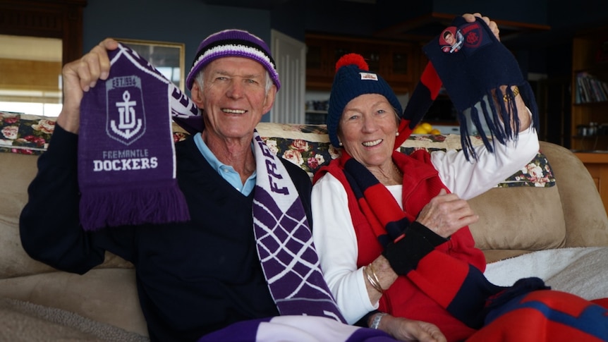 two people in football gear, smiling 