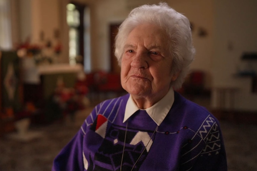 An elderly woman smiles happily 