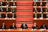 Chinese President Xi Jinping speaks surrounded by members of the Communist Party.