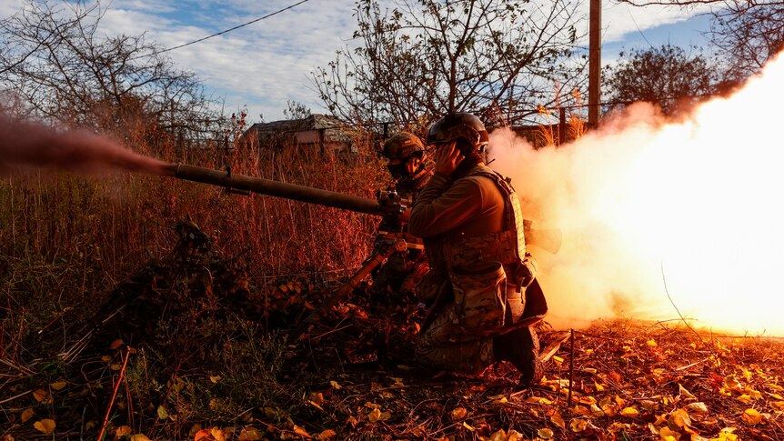 Ukrainian soldiers fire an anti-tank grenade launcher towards Russian troops.