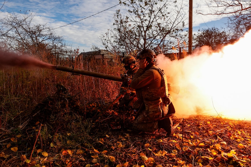 Ukrainian soldiers fire an anti-tank grenade launcher towards Russian troops.