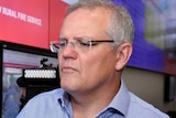 Scott Morrison looks at a screen at the RFS headquarters as a photographer and cameraman stand behind him