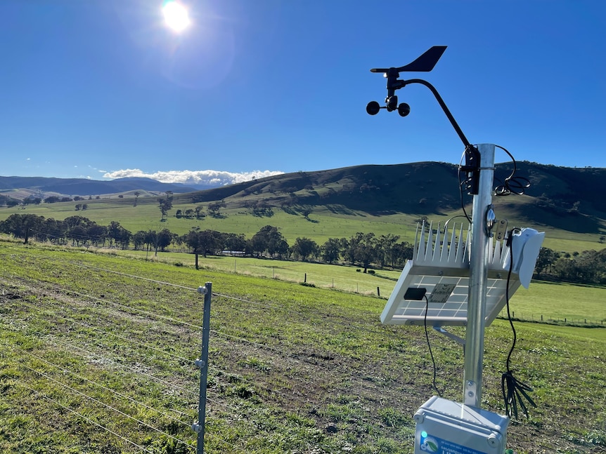 Picture showing part of a weather monitoring station at Ensay. A solar panel faces the sun and a wind vane is mounted above it.