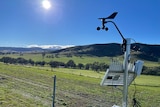 Picture showing part of a weather monitoring station at Ensay. A solar panel faces the sun and a wind vane is mounted above it.