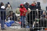 A migrant girl waits to enter a makeshift camp at the Austrian-Slovenian border