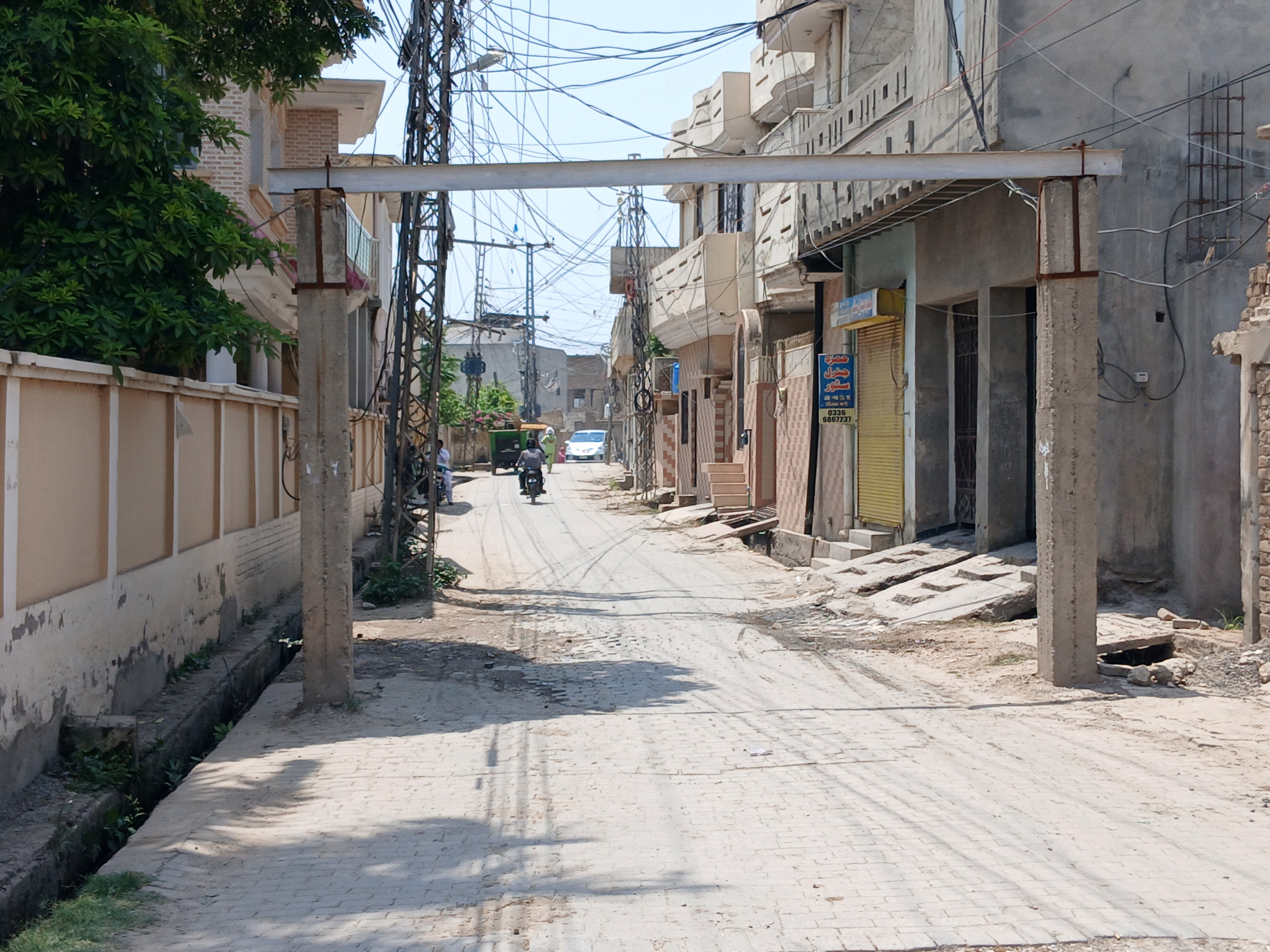 A street in Pakistan, with a motorbike in the distance.