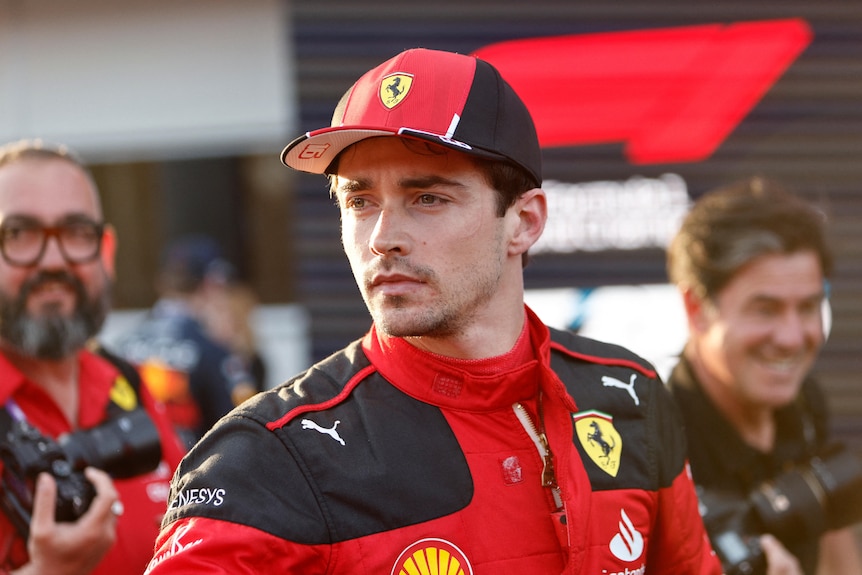 Charles Leclerc, wearing a cap and racing suit, stares into the distance after taking pole at the Azerbaijan Grand Prix