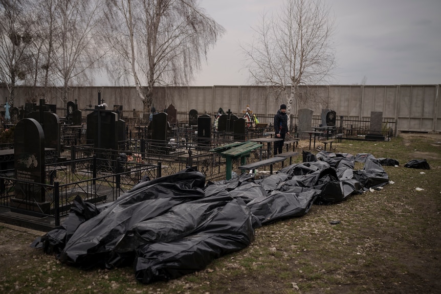 Bodies in black bags lay on the floor in a graveyard in Ukraine.