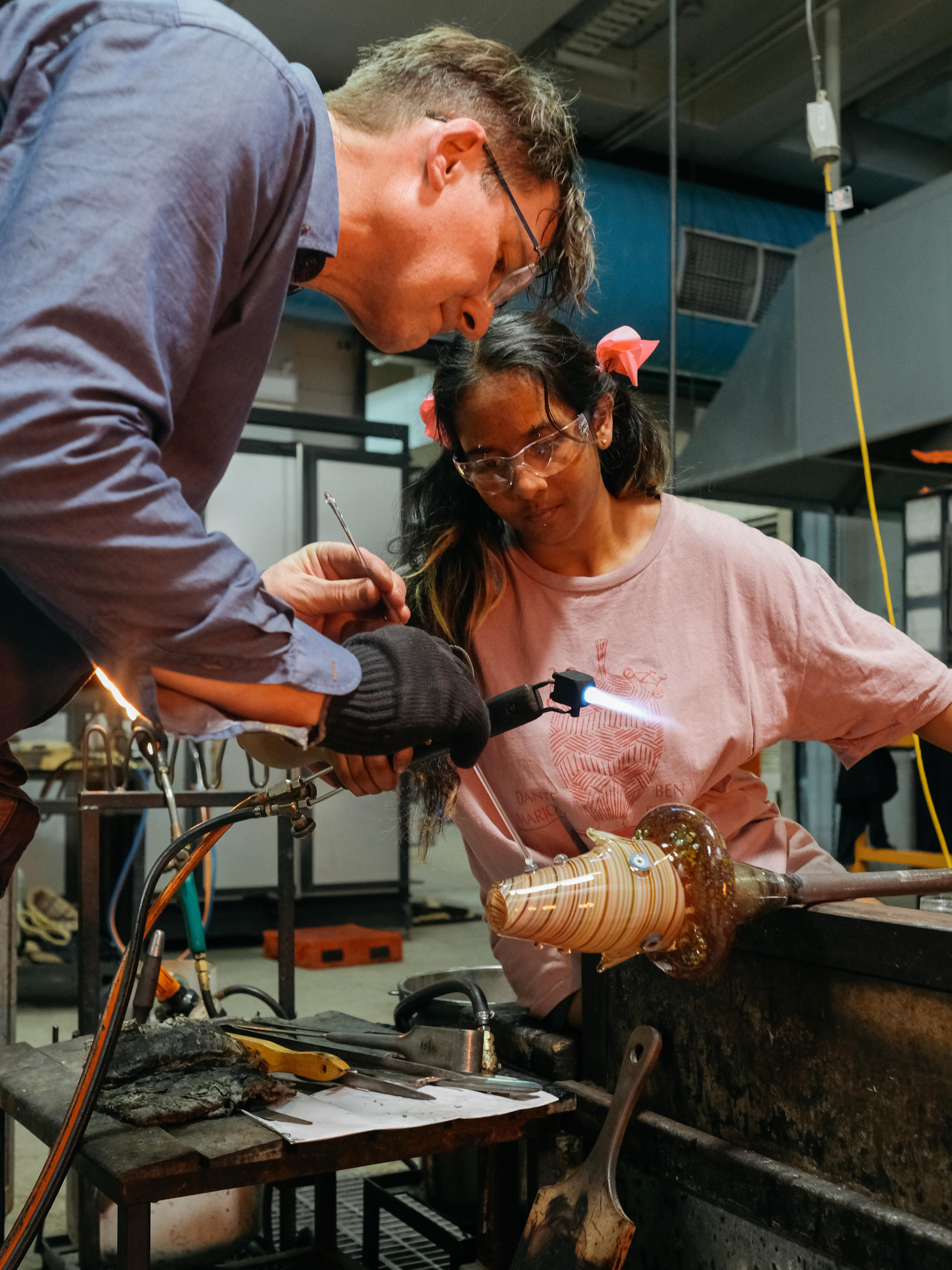 Artist Tom Moore and glass making assistant Gautriya Murathietharan work together on a hot glass sculpture