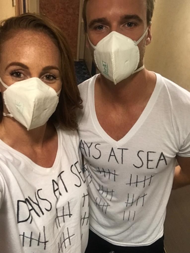 A man and a woman both wearing white masks wearing white shirts that say 'days at sea' with a tally of days