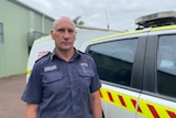 Wayne stands next to a fire emergency vehicle wearing blue DFES uniform