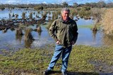 Middle-aged man standing in front of a wetland.