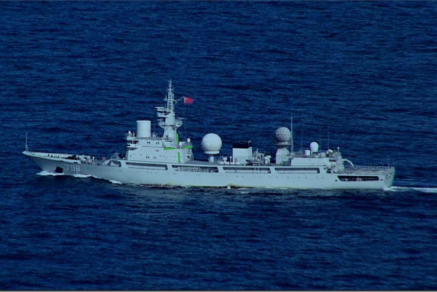 A navy surveilance ship with a Chines flag on it in the ocean