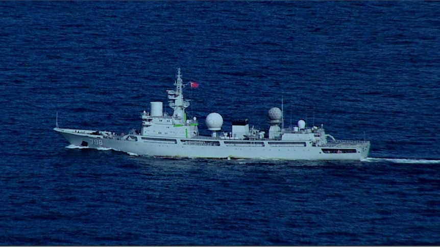 A navy surveilance ship with a Chines flag on it in the ocean