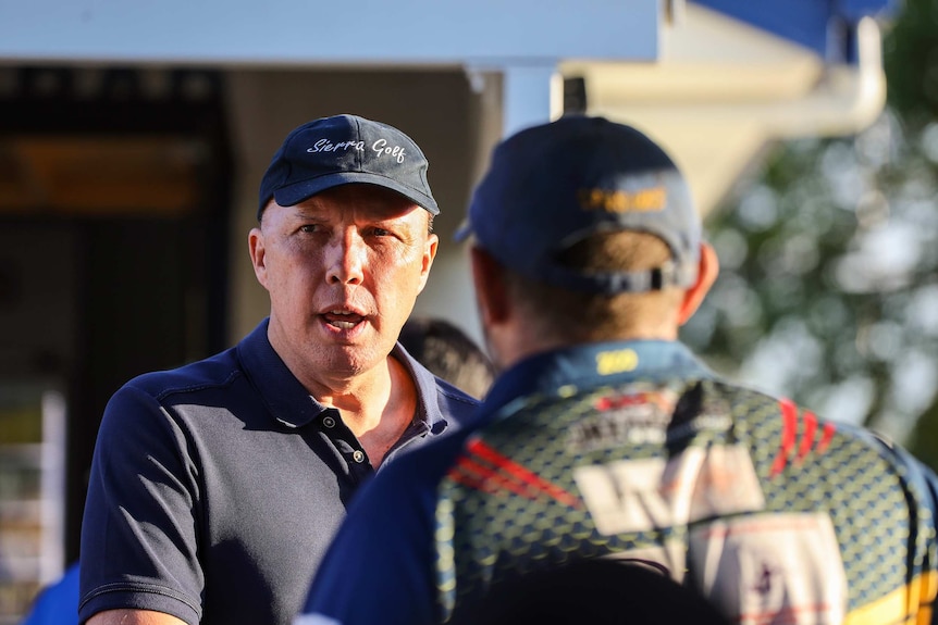 Peter Dutton talks to a man at a junior rugby game in March 2019.
