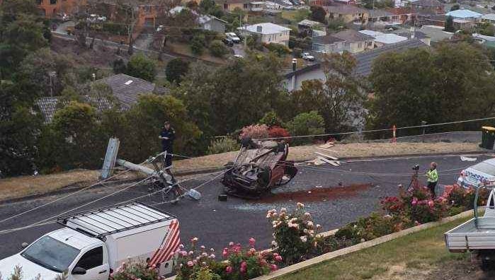 Overturned car near snapped power pole.