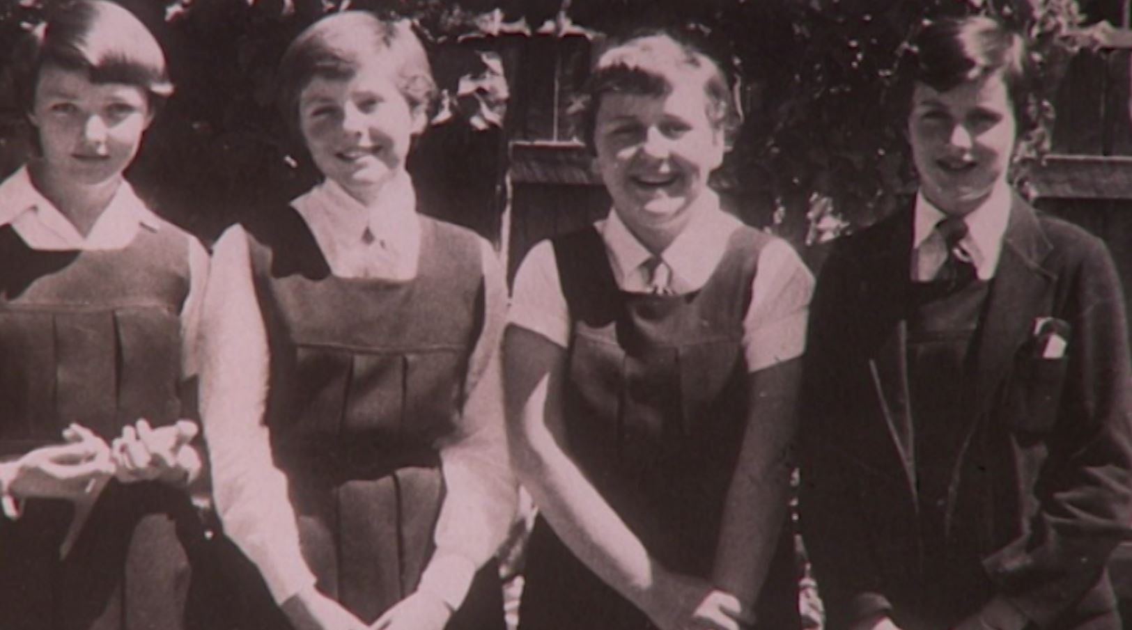 Black and white 1950s photograph of four school girls in uniform