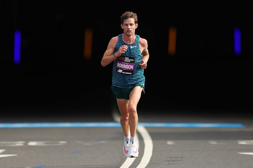 Australian Brett Robinson runs alone on a road during the London marathon.